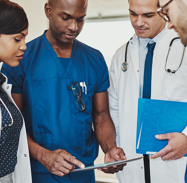 Photo of healthcare professionals reviewing a chart on a tablet