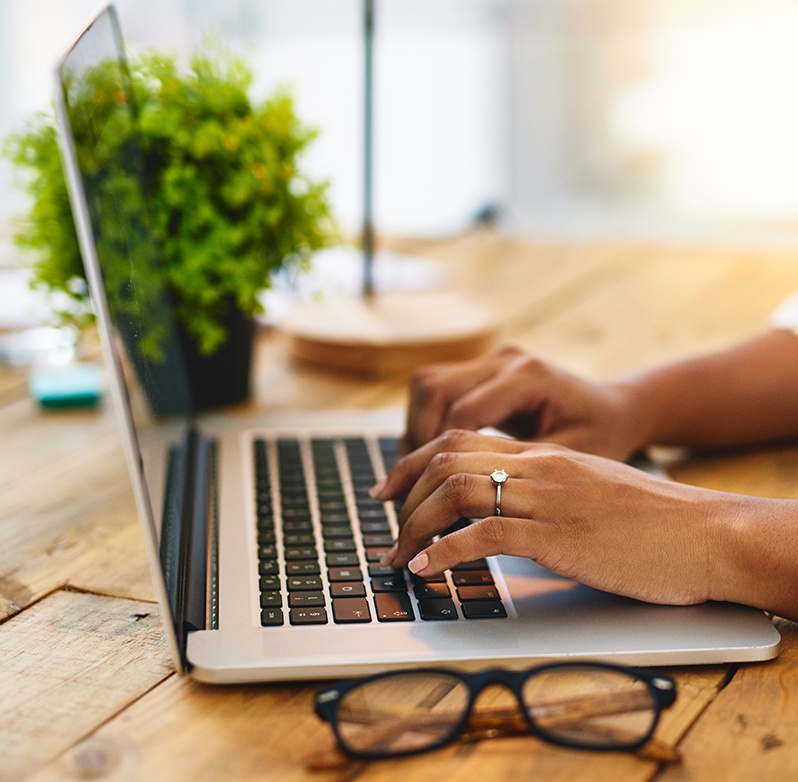 Photo of a woman typing on a laptop