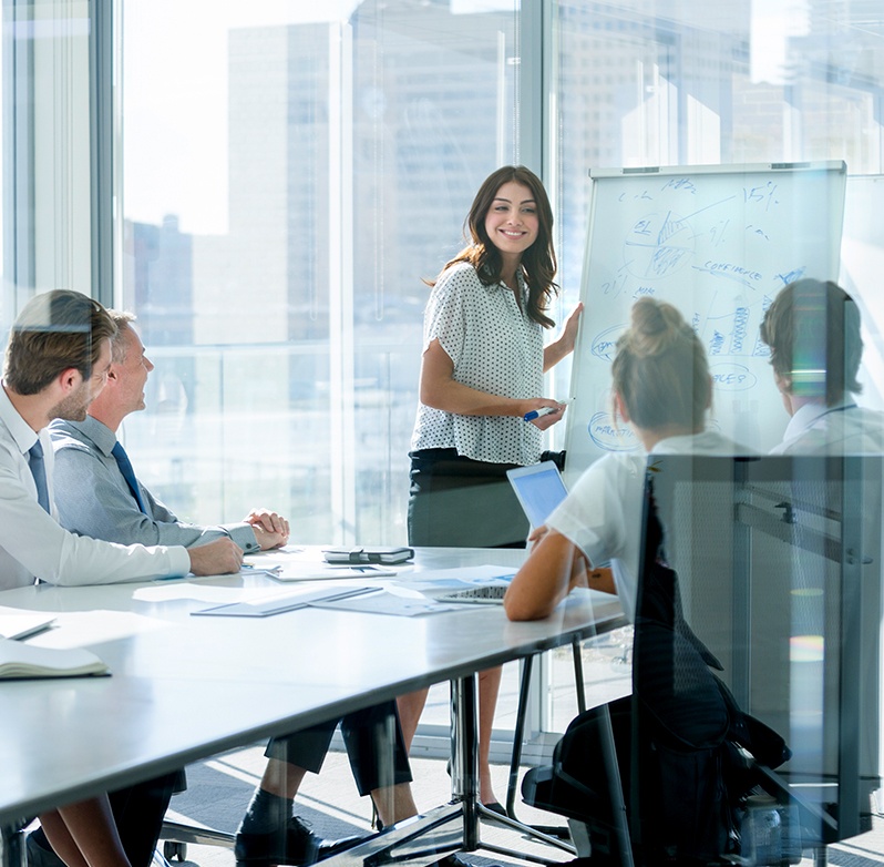 Photo of woman making a presentation to a conference room of people
