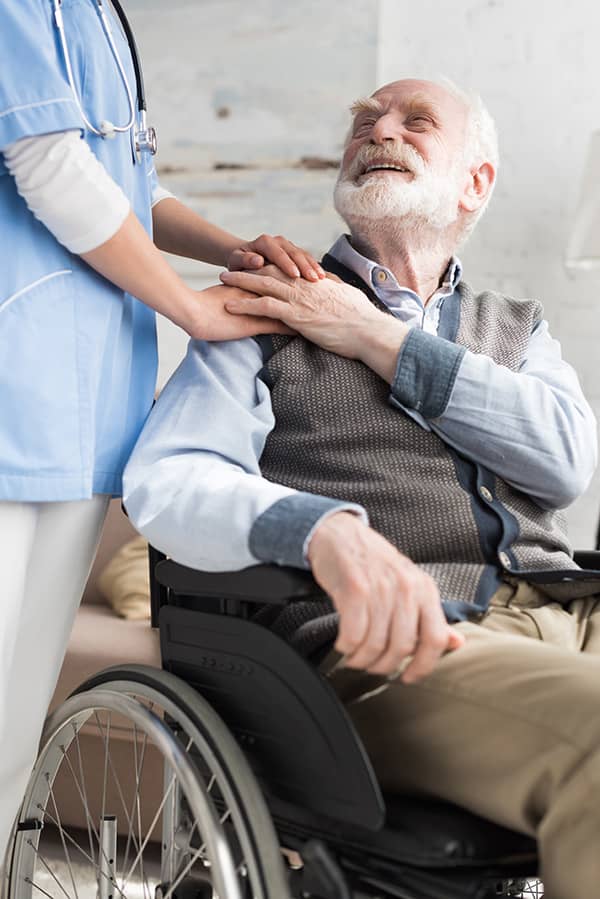 Home health nurse cares for senior man in wheelchair